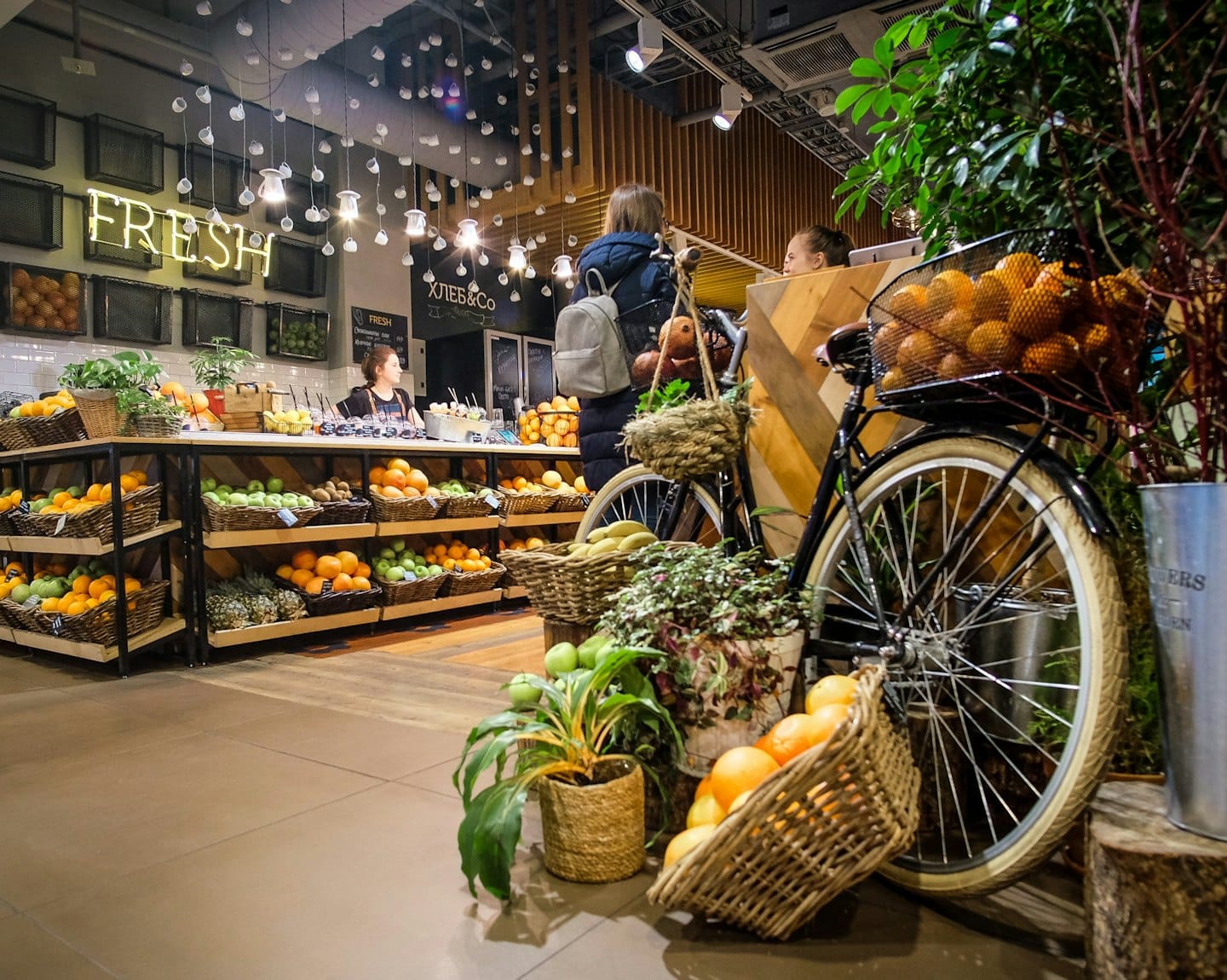Customers and staff interact at a grocery store featuring fresh produce.
