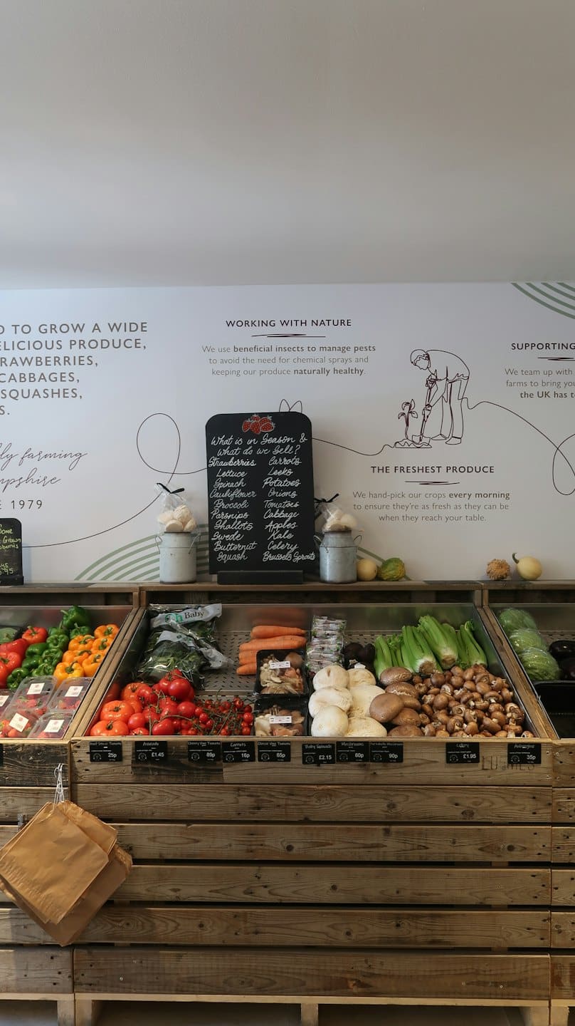 Fresh produce arranged in rustic wooden crates at a farm shop.